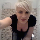 A pretty blonde woman with short hair squats backwards over a toilet and takes a shit. She wipes her ass, shows us the dirty toilet paper and then her product in the bowl while flushing. See movie 10108 for more. About 4.5 minutes.